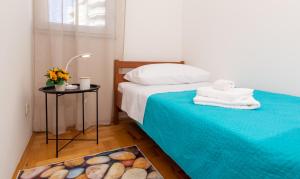 ein Schlafzimmer mit einem Bett mit Handtüchern und einem Tisch in der Unterkunft Dare in Split