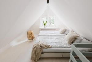 a white bedroom with a bed and a window at Drewniana Róża Willa Karkonosze in Piechowice
