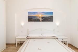 a bedroom with a white bed and white walls at Tramonto sul mare in Santa Teresa Gallura