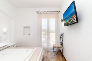 a room with a white wall and a blue floor at Tramonto sul mare in Santa Teresa Gallura