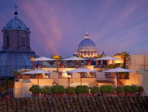 ein Gebäude mit einer Kathedrale und einem Gebäude mit Sonnenschirmen in der Unterkunft Bio Hotel Raphael - Relais & Châteaux in Rom