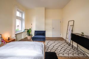a bedroom with a bed and a blue chair at living TIMELESS- Europa Park- Kippenheim in Kippenheim
