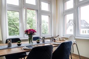comedor con mesa, sillas y ventanas en Nähe Europa Park! Exklusive Ferienwohnung mit 140 qm!, en Kippenheim