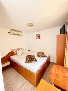 a bedroom with a bed with a leopard blanket on it at Camere de inchiriat Sibel in Costinesti