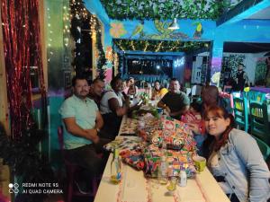 a group of people sitting around a long table with presents at El Patio de mi Casa Hotel Restaurante in Salento