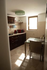 a kitchen with a table and a window in it at Trullo Bianco in Putignano +18 photos