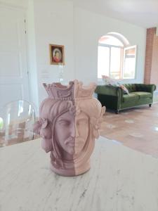 eine Statue eines Kopfes mit einer Krone auf dem Tisch in der Unterkunft La Ricarda Dimora di Campagna in Paestum