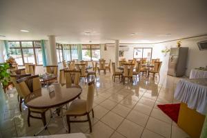 a dining room with tables and chairs in a restaurant at Hotel di Fratelli in Dois Irmãos