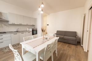 Una cocina y un comedor con una mesa y sillas blancas. en Appartamento L'Essenziale, en Vieste 10 fotos más