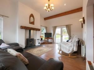 a living room with a couch and a fireplace at The Heights & Hollows Farmhouse, Saul, Downpatrick, SLEEPS 14 in Downpatrick