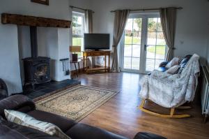 a living room with a couch and a fireplace at The Heights & Hollows Farmhouse, Saul, Downpatrick, SLEEPS 14 in Downpatrick