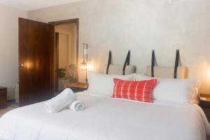 a bedroom with a white bed with red and white pillows at Tradewinds Apartments Simpson Bay in Simpson Bay