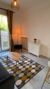 salon z kanapą, stołem i dywanem w obiekcie Appartement entier. Nice Riquier w Nicei