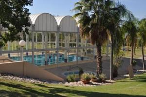 un grand bâtiment avec une piscine et des palmiers dans l'établissement lasuita-exclusive suites ceserea-sunset suite, à Césarée