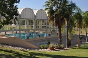 a large building with a swimming pool and palm trees at lasuita-exclusive suites ceserea-sunset suite in Caesarea