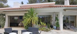una casa con sedie e una palma su un patio di Villa d'exception piscine & domaine privé Mougins a Mougins