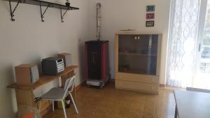 un soggiorno con TV e scrivania con sedia di Abete Bianco a Serra San Bruno