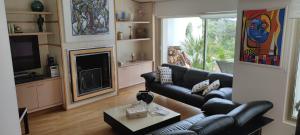 un soggiorno con divano in pelle nera e camino di Villa d'exception piscine & domaine privé Mougins a Mougins