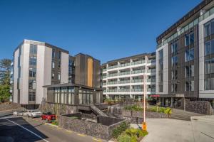 a street with two tall buildings and a parking lot at City Pulse Apartment with car park and city views in Auckland