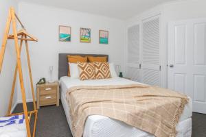 een slaapkamer met een bed en een statief bij Inner City One Bedroom Apartment with Pool View 22 in Cairns