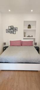 ein weißes Bett mit zwei roten Kissen im Schlafzimmer in der Unterkunft SMART HOME in Triest