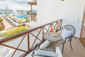 un balcone con tavolo, sedie e piscina di Sweet Celia a Playa Blanca