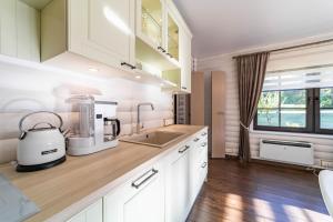 a kitchen with white cabinets and a counter top at Hara Beach house in Hara