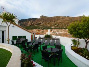 a patio with tables and chairs with a mountain in the background at Hotel Sierra de Huesa in Huesa