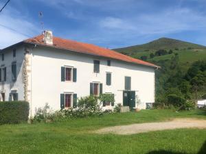 une maison blanche avec une colline en arrière-plan dans l'établissement Un écrin dans la nature, à Espelette