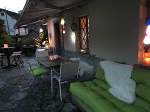 Casa Eva في Brione: غرفة معيشة مع أريكة خضراء وطاولة