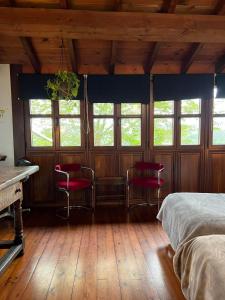 ビリャビシオサにあるArcenoyu Rural innのベッドルーム(赤い椅子、ベッド、窓付)