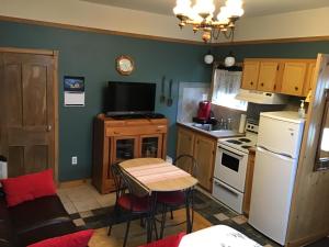 a kitchen with a table and a small kitchen with a refrigerator at Chez Odette, loft intime in Roberval