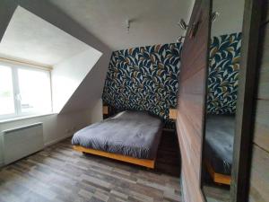 Cette petite chambre mansardée comprend un lit. dans l'établissement Charmant appartement proche commerces et plages, au Guilvinec