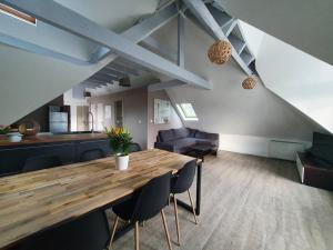 uma sala de jantar e cozinha com mesa e cadeiras de madeira em Charmant appartement proche commerces et plages em Le Guilvinec