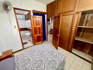 a room with a bedroom with a bed and wooden cabinets at Hostal Inn 1 in Flores +7 photos