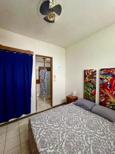 a bedroom with a bed and a blue curtain at Hostal Inn 1 in Flores