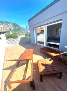 a deck with a bed and a bench on a house at Garda Family & Solarium in Riva del Garda