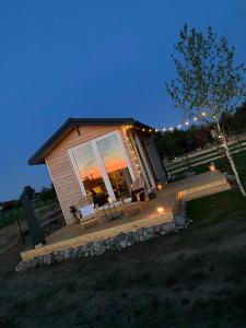 a log cabin with a patio and a tree at Brzozowisko Zalewo in Miłomłyn