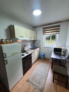 uma cozinha com um frigorífico branco e uma mesa em Apartmani Podvisoki em Visoko