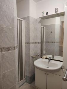 ein weißes Bad mit einem Waschbecken und einer Dusche in der Unterkunft Le case di Grazia in Ioppolo Giancaxio