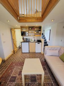 a living room with a couch and a kitchen at The Little Bothy - Holiday Cottage in the heart of Monmouthshire in Llanfaenor