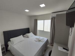 ein Schlafzimmer mit einem weißen Bett mit einer Schleife darauf in der Unterkunft Pousada Maria Bonita Porto De Galinhas in Porto De Galinhas