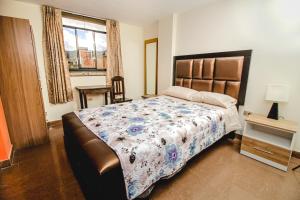 sypialnia z dużym łóżkiem i oknem w obiekcie Antara Hostal w mieście Cajamarca