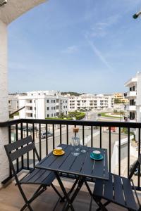 a table and chairs on a balcony with a view of a city at Appartamento L'Essenziale in Vieste