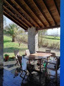 a wooden table and chairs on a patio at La casa azul de Lua Un lugar mágico in Juncedo-Campo