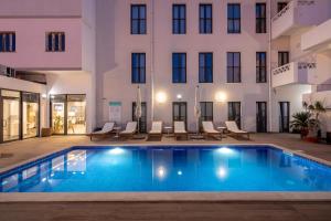 a swimming pool in the courtyard of a building with a hotel at Hotel Cidade de Olhão in Olhão