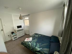 Habitación pequeña con cama y escritorio. en The White Room, en Plymouth