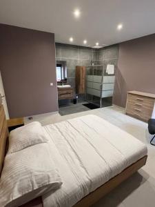 een slaapkamer met een groot bed en een badkamer bij Belle appartement avec parking gratuit in Blanzy