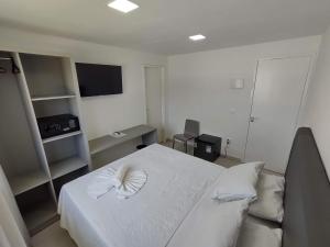 ein Schlafzimmer mit einem weißen Bett mit einer weißen Schleife darauf in der Unterkunft Pousada Maria Bonita Porto De Galinhas in Porto De Galinhas