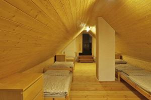 Chata Ryba في Pernink: غرفة بأربعة أسرة في سقف خشبي